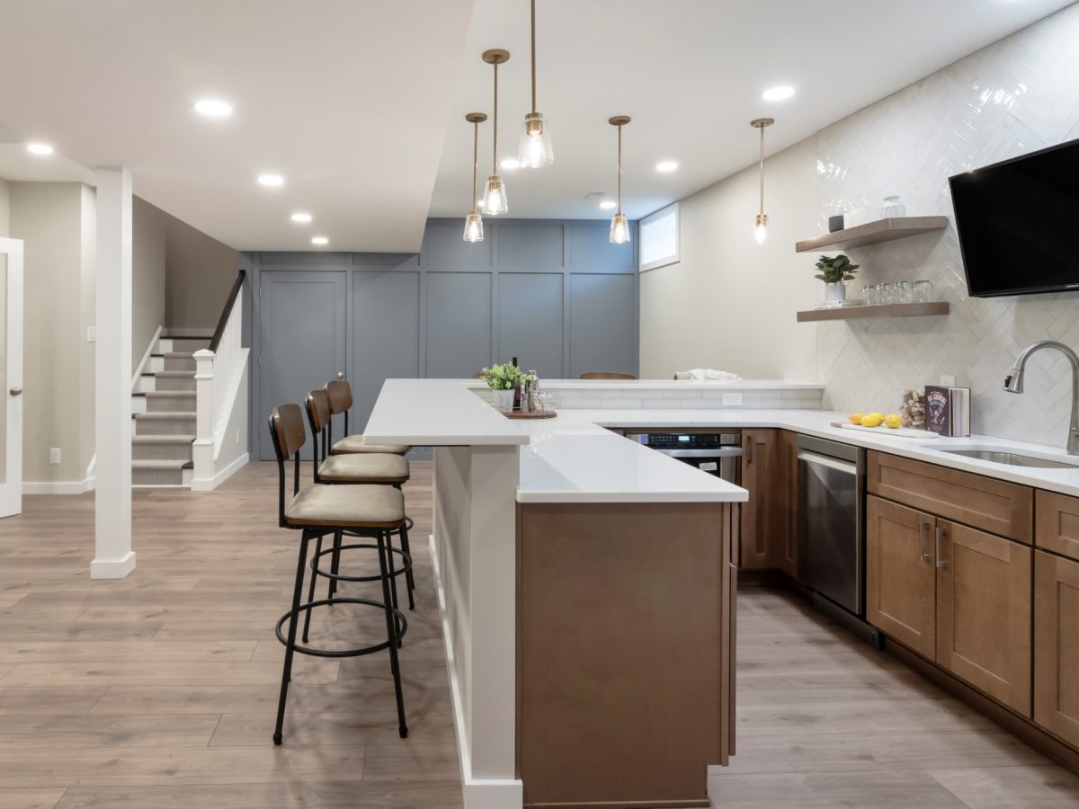 A finished lower-level living space with a custom bar designed by Yellow Stone Interior Design