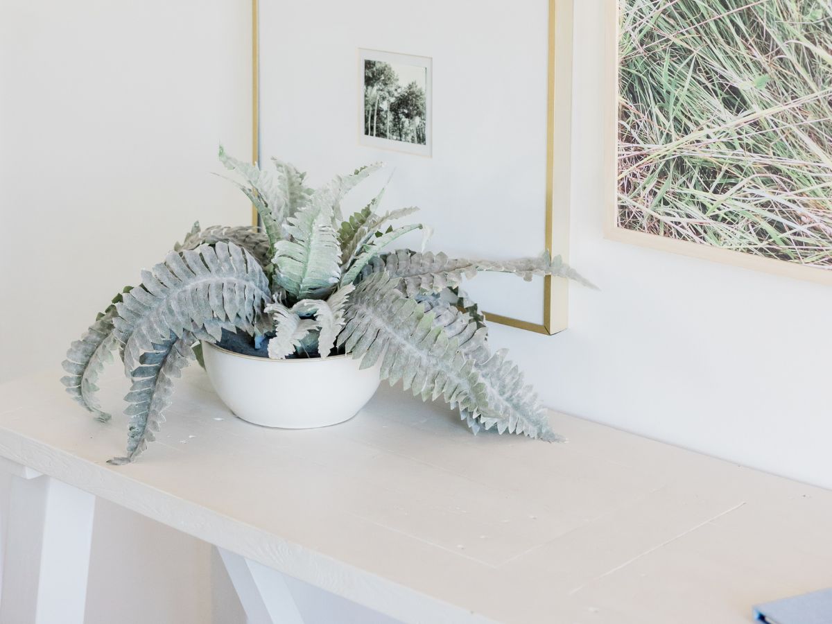 Welcoming entryway table styled with art and greenery